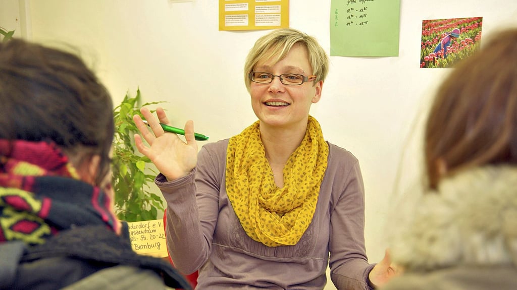 Eine Schulsozialarbeiterin im Gespräch mit Kindern