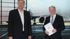Markus Otto (l) und Reiner Haseloff (CDU) stehen im Flughafen Leipzig/Halle vor dem Plakat eines Flugzeugs.