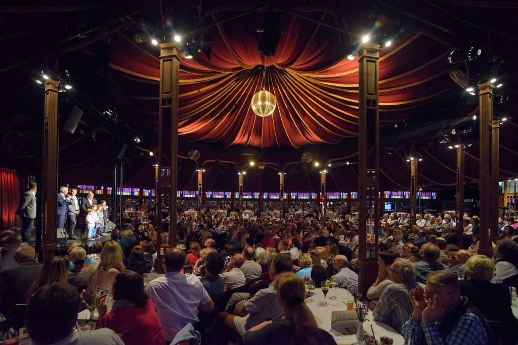 Zuschauer sitzen während des Auftakts zum Musik- und Kabarett-Festival im Köstritzer Spiegelzelt.