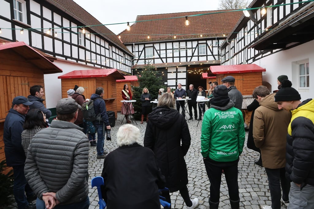 Besucher stehen am Weihnachtsmarkt bei der Eröffnung der Weihnachtsbaumsaison des Thüringer Tannenhofes.