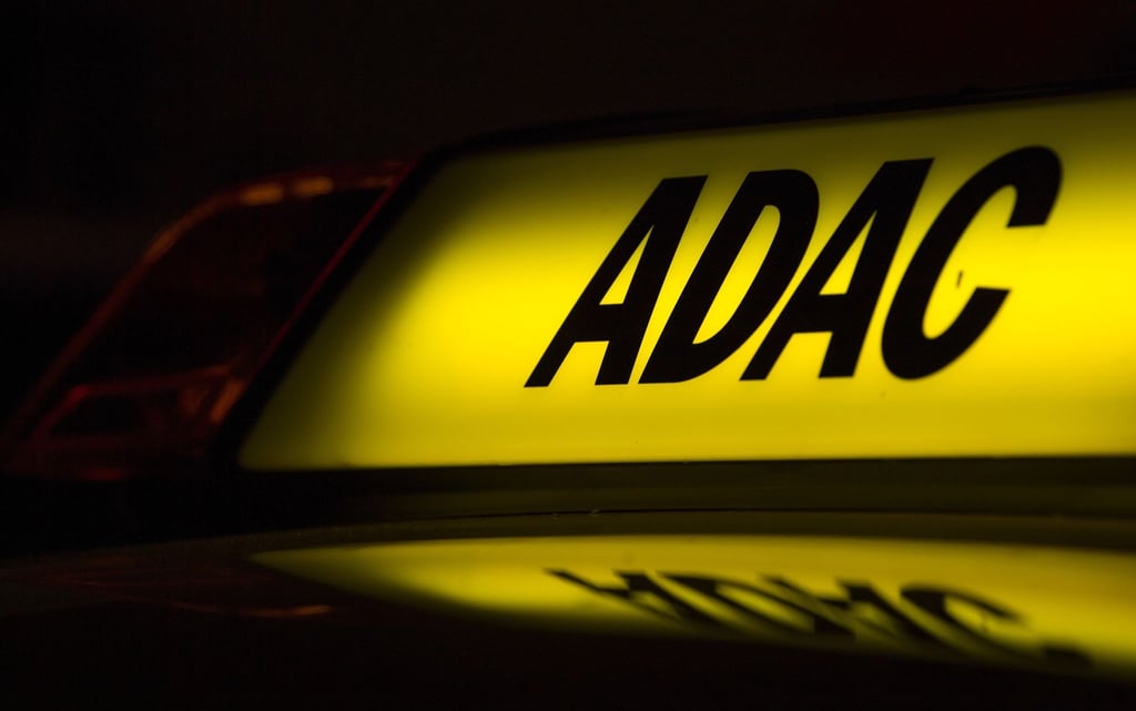 Die Abkürzung „ADAC“ auf einem Fahrzeug leuchtet in der Dunkelheit.