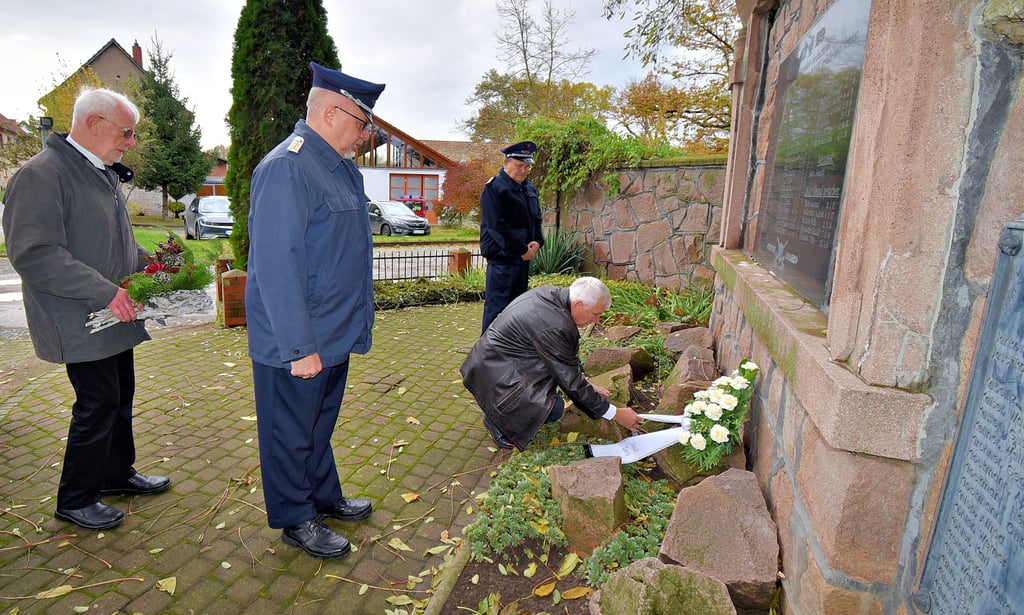 Egelns Bürgermeister Reinhard Luckjner und der Superindent i. R. Peter Telchow legten zusammen mit Feuerwehr-Kameraden in Egeln-Nored Kränze beziehungsweise Gestecke am Denkmal für die Gefallenen des Dorfes nieder.
