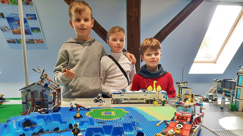 Conrad Christel sowie Henriette und Leopold Stehl (v.l.n.r.) präsentieren einen Teil der Legostadt, die ans Legomeer grenzt und die sie am Wochenende mit aufgebaut haben.