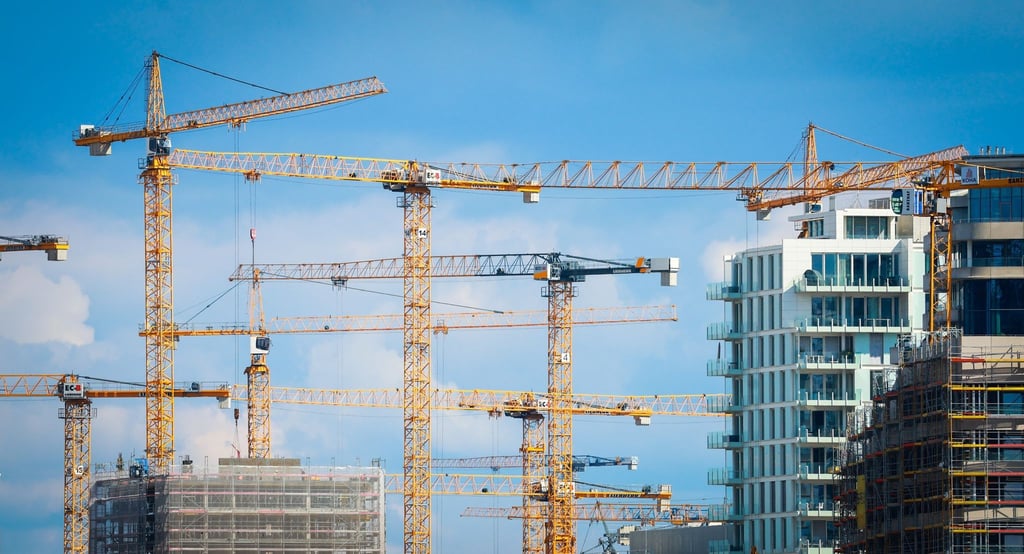 Baukräne stehen auf einer Baustelle in einer Innenstadt.