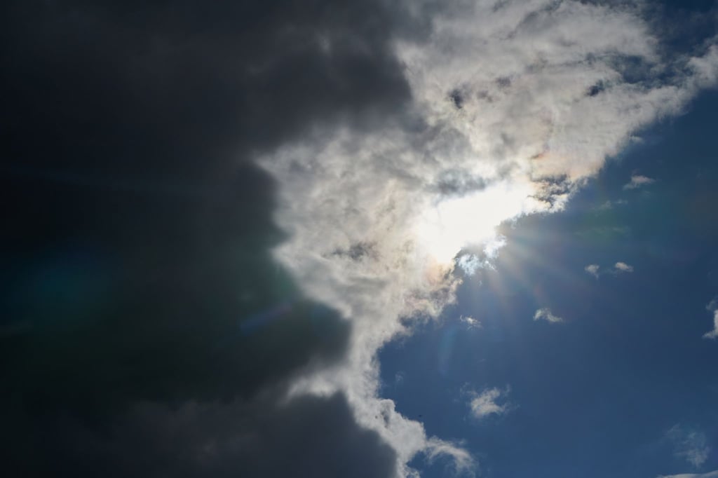 Die Sonne kommt hinter Regenwolken hervor.