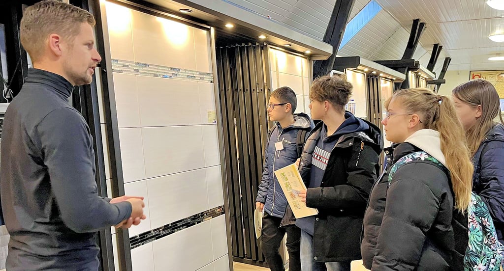 Albert Ernst, Unternehmer aus Roßdorf, führt die Achtklässler durch sein Unternehmen, das mit Fliesen handelt.