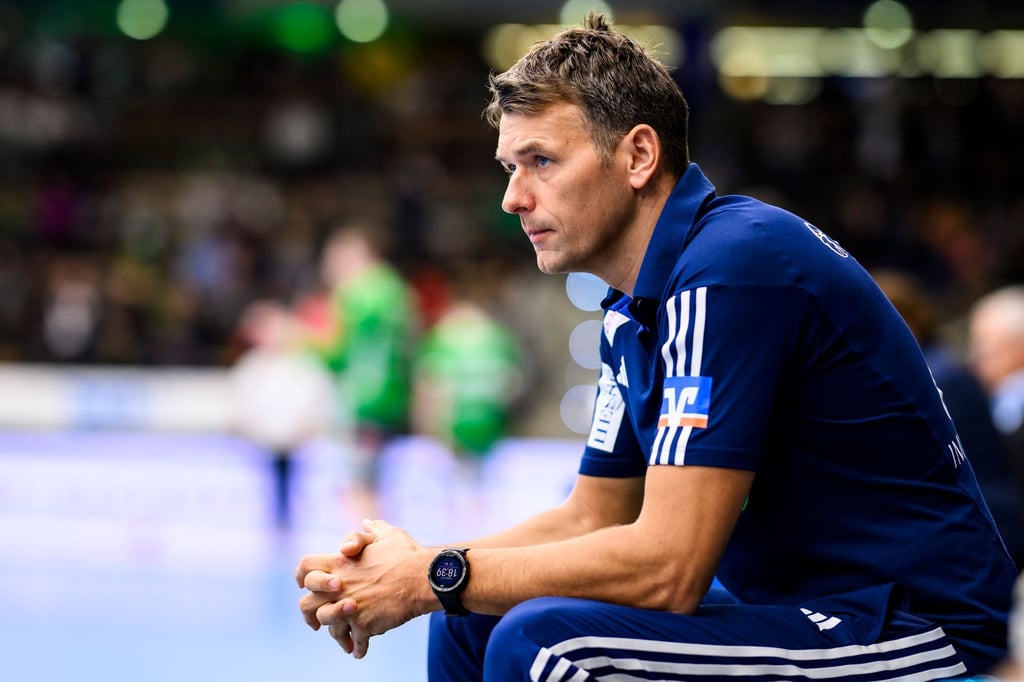 Hannovers Trainer Christian Prokop sitzt vor einem Spiel in der Halle.