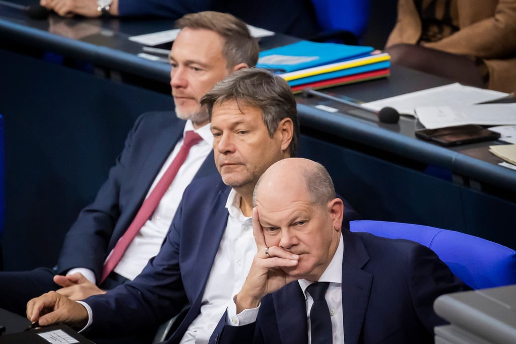 Bundeskanzler Olaf Scholz (SPD, r-l), Wirtschaftsminister Robert Habeck (Bündnis 90/Die Grünen) und Finanzminister Christian Lindner (FDP) verfolgen im Deutschen Bundestag die Debatte.