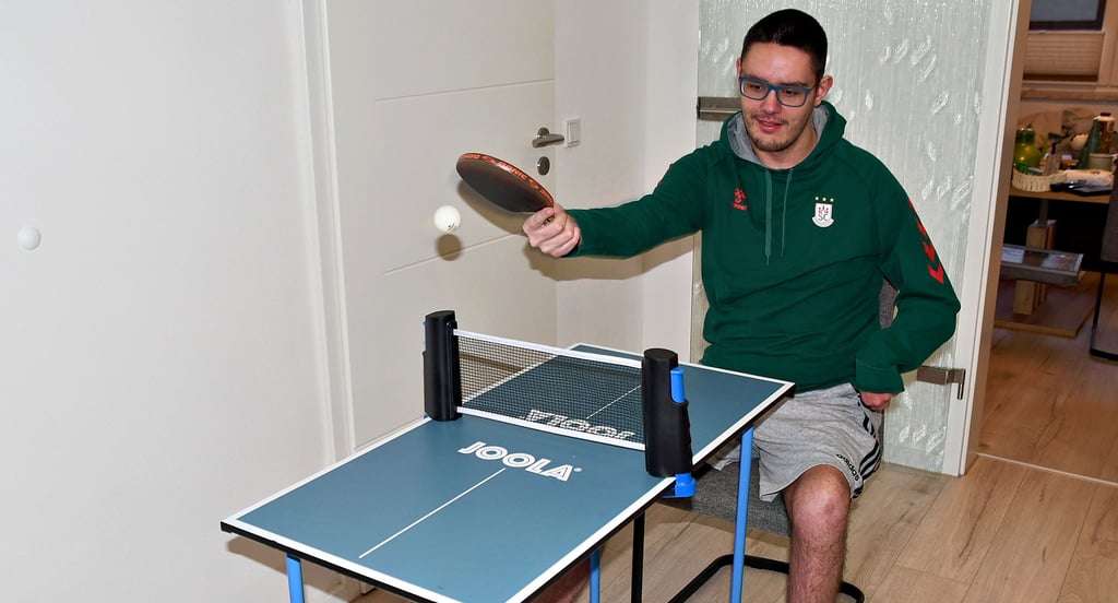 Hannes Arnhold zu Hause an der Mini-Tischtennis-Platte. Wegen der halbseitigen Lähmung wirft er den Ball beim Aufschlag mit derselben Hand hoch, in der er auch den Schläger hält.