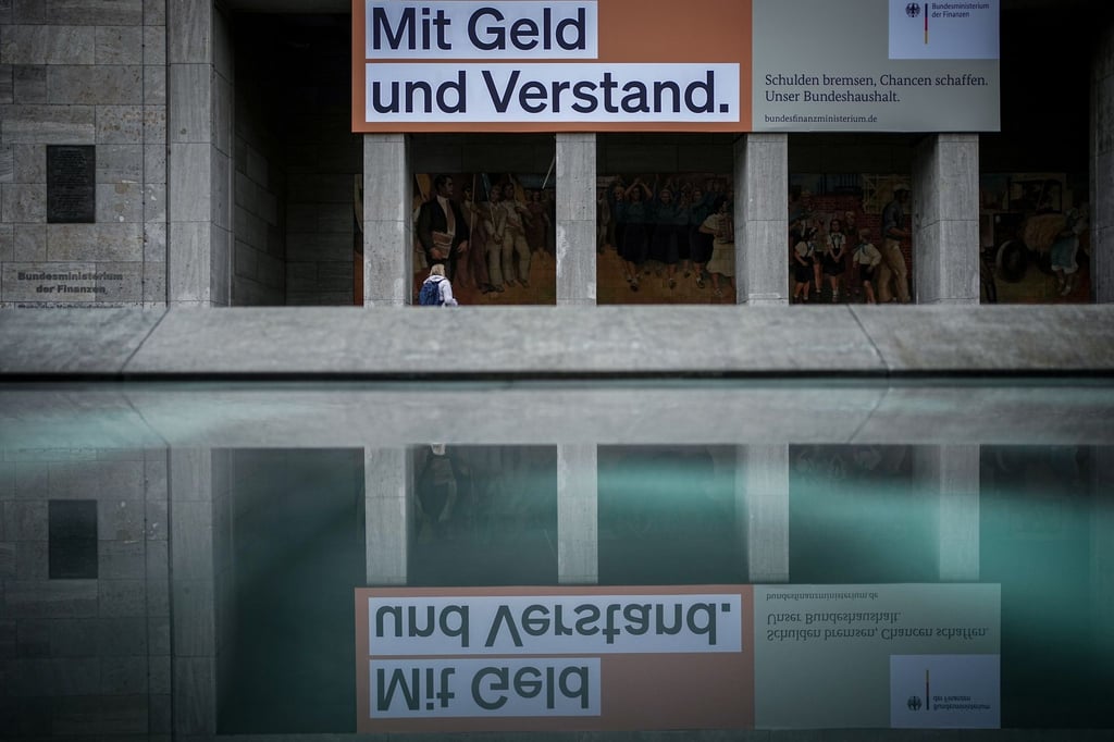 Ein Plakat mit der Aufschrift „Mit Geld und Verstand. Schulden bremsen, Chancen schaffen. Unser Bundeshaushalt.“ hängt über dem Eingang zum Bundesministerium der Finanzen.
