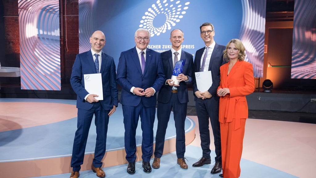 David M. Grodzki (l-r), Bundespräsident Frank-Walter Steinmeier, Stephan Biber, Michael Uder und Moderation Yve Fehring stehen nach der Verleihung des Deutschen Zukunftspreises 2023 zusammen.