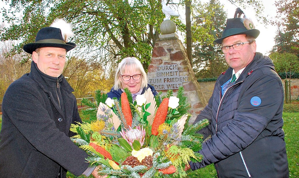 Denis Machoi, Petra Volkmann und Winfried Künne bei der Kranzniederlegung in Domersleben.