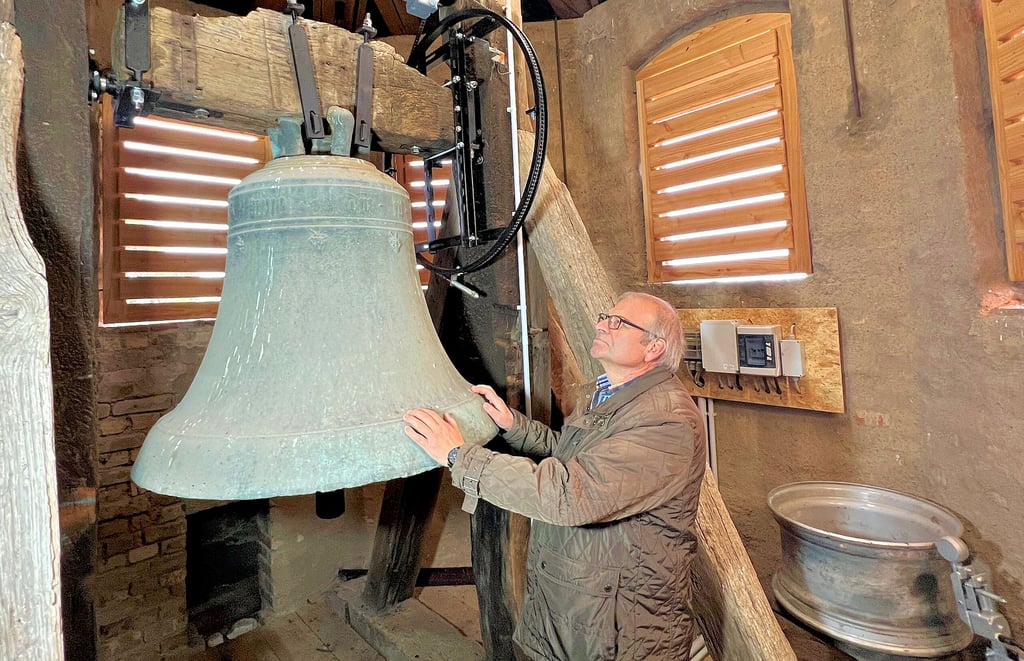 Bernburgs Hochbauamtsleiter Rüdiger Ihl steht im Glockenstuhl des Wohlsdorfer Kirchturms, wo sowohl die historische Glocke als auch eine alte Lkw-Felge (rechts) geläutet werden können.