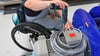 An einem Arbeitsplatz für Motorklemmen ist ein Mitarbeiter im Rollstuhl mit Montagearbeiten beschäftigt.