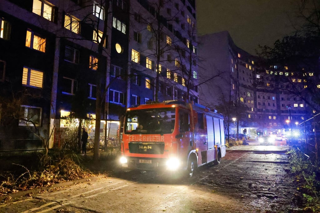 Einsatzkräfte der Feuerwehr stehen bei einem Einsatz vor einem Hochhaus in Berlin-Friedrichshain.