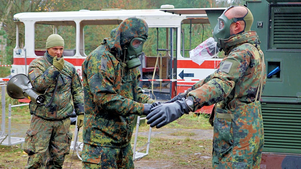 Bei der Nato-Logistikübung „Blue Lightning“ zeigen Soldaten, wie kontaminierte Schutzanzüge ausgezogen werden.