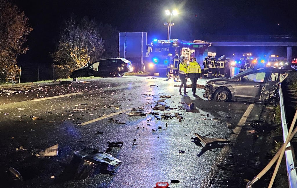 Polizisten und Feuerwehrleute arbeiten im Trümmerfeld auf der Autobahn A31.