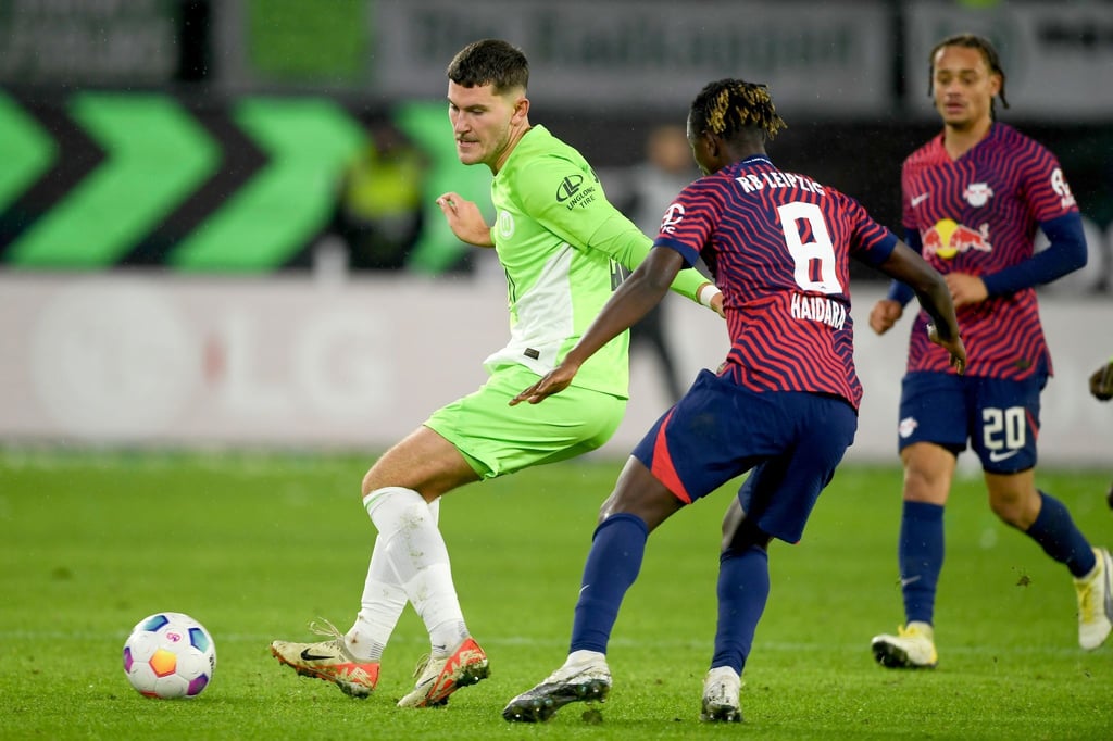 Wolfsburgs Jonas Wind (l.) spielt gegen Leipzigs Amadou Haidara.