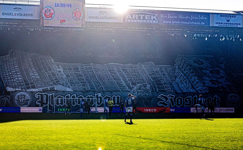 Hansa-Fans haben ein Banner mit Häusern aus Rostock-Lichtenhagen über die Tribüne gezogen.