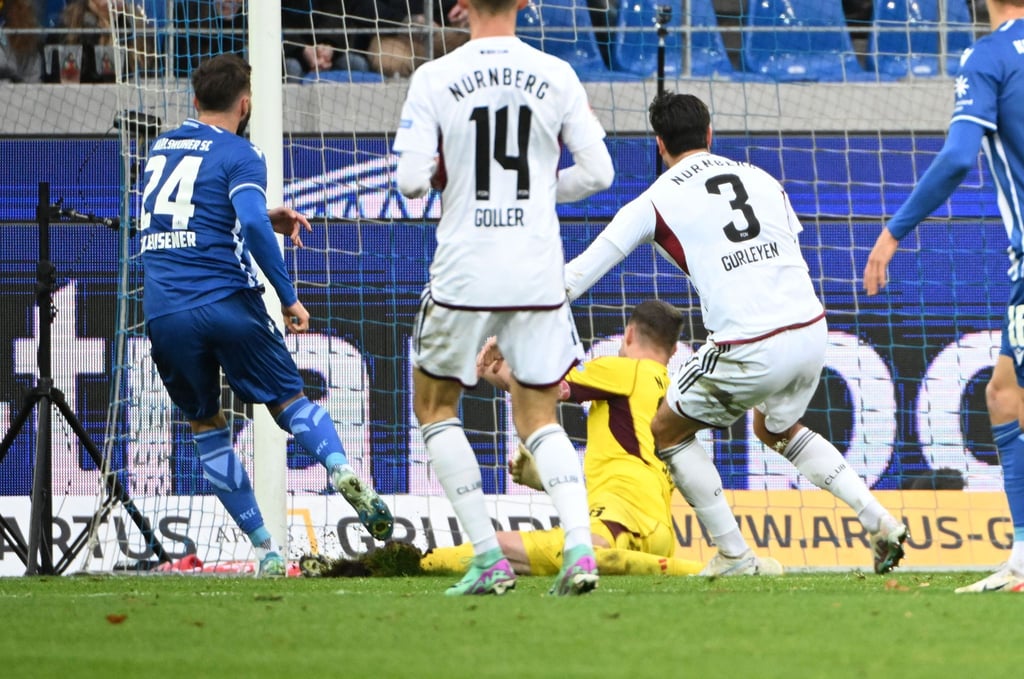 Der Karlsruher Fabian Schleusener (l) erzielt den Treffer zum 2:1 gegen den 1. FC Nürnberg.