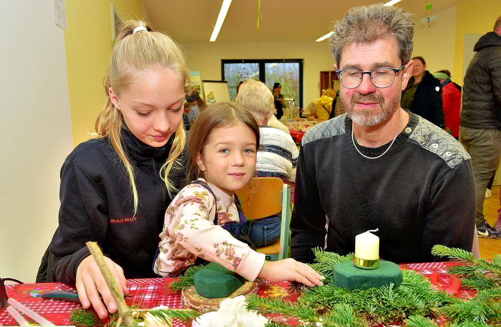 Von links: Leni und Mascha Röthemeyer basteln mit Papa Torsten Schlabs in der Ökostation Neugattersleben Adventsgestecke für die Weihnachtszeit.