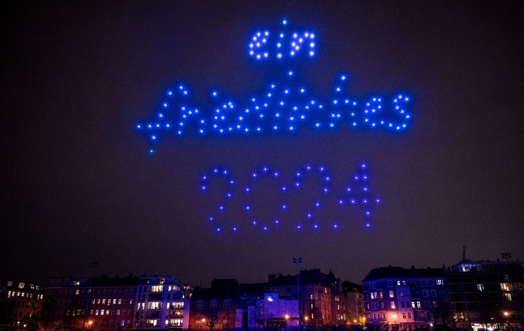 Leuchtende Drohnen fliegen bei einer Drohnenshow.
