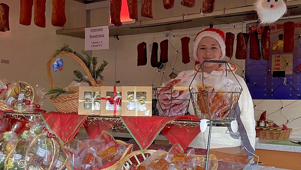 An Ständen werden verschiedene Waren angeboten.