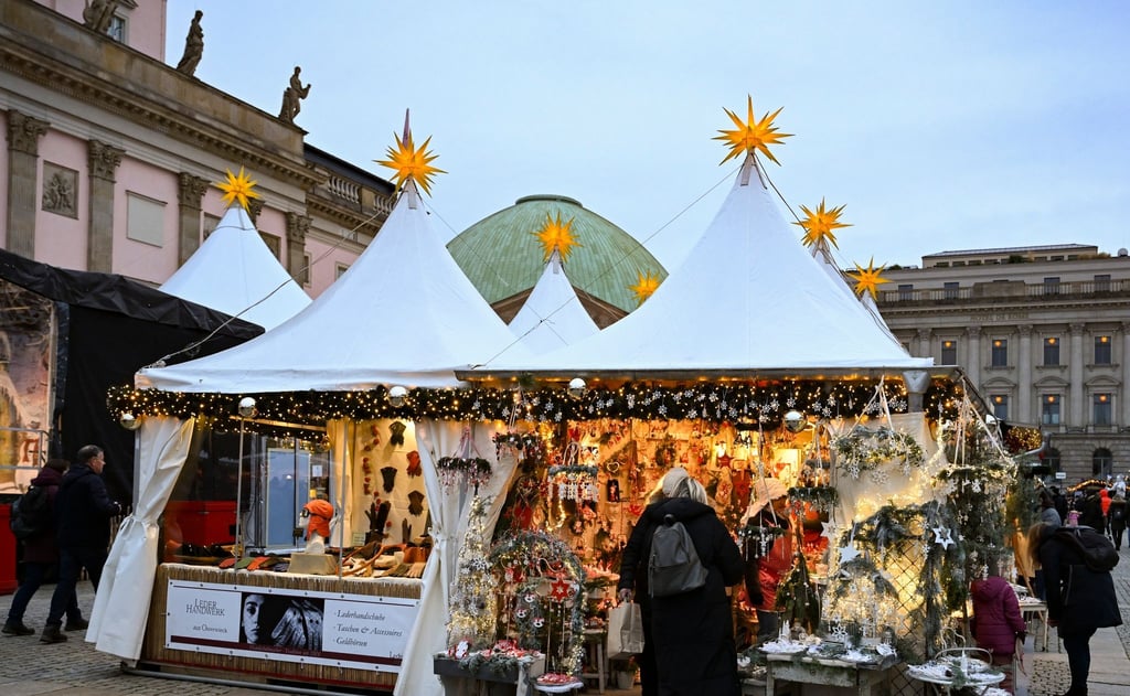 Die ersten Besucher kommen auf den Weihnachtsmarkt auf dem Bebelplatz an der Staatsoper.