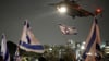 Menschen schwenken in Petach Tikwa israelische Fahnen, während ein Hubschrauber mit Geiseln, die von der Hamas aus dem Gazastreifen freigelassen wurden, landet (Archivbild).