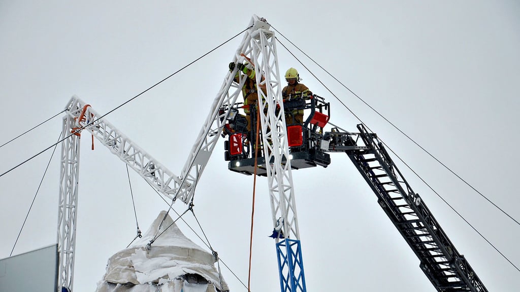 Kameraden der Freiwilligen Feuerwehr Staßfurt sichern am geknickten Quermast die Zeltplane, damit sie unversehrt zu Boden gelassen werden kann. Für die Hilfe bedankt sich die Zirkuschefin spontan mit Freikarten.