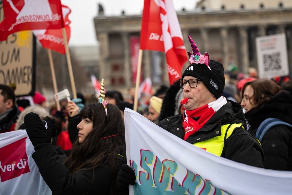 Ein Demonstrant steht mit einer Trillerpfeife im Mund auf dem Schlossplatz.