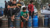 Palästinensische Kinder in Chan Junis stehen Schlange, um Flüssiggasflaschen aufzufüllen.