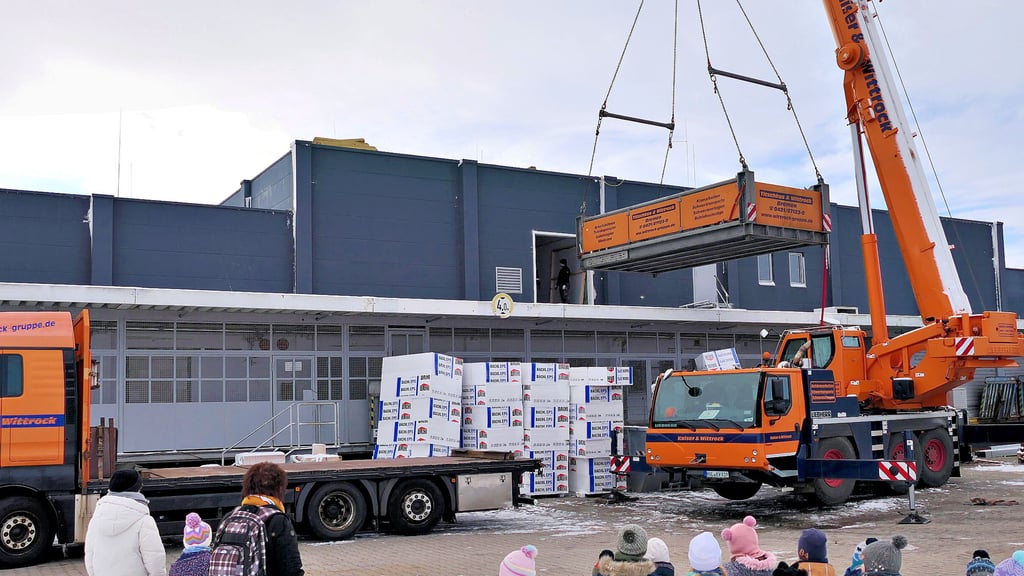 Die Mädchen und Jungen der Staßfurter Kita Struwwelpeter beobachten gespannt, wie die Kältemaschine auf das Dach der neuen Kaufland-Filiale gehoben wird.