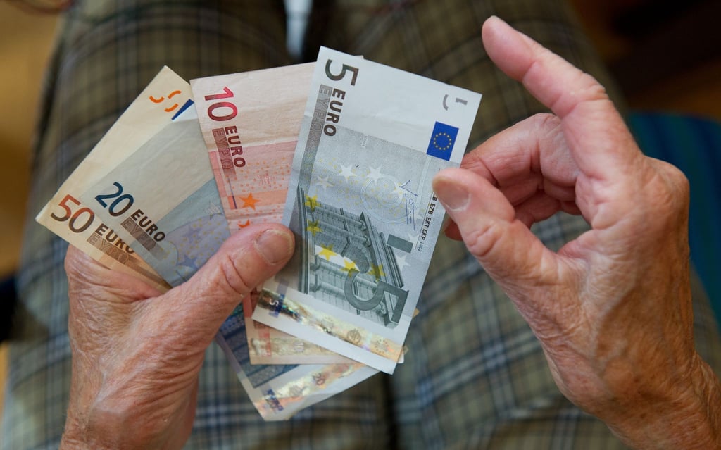 Eine ältere Frau zählt Geld.