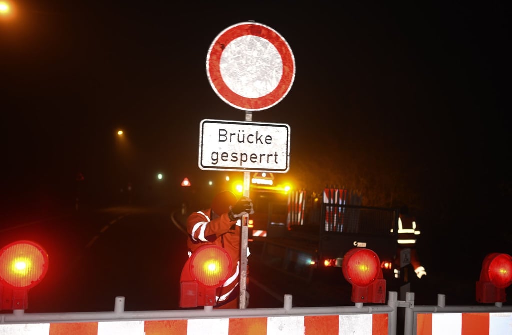 Mitarbeiter der Straßenmeisterei stellen Barken zur Absperrung der Jann-Berghaus-Brücke auf.