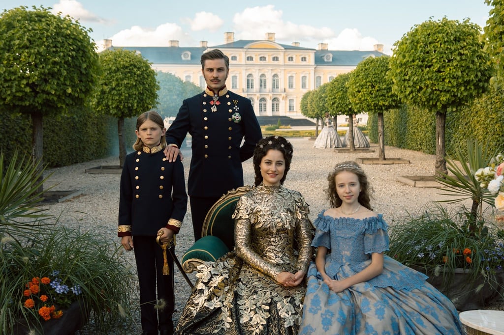 Anlässlich ihrer Rückkehr nach Wien treten Sisi (Dominique Devenport, 2.v.r.) und Franz (Jannik Schümann, 2.v.l.) mit ihren Kindern Gisela (Kristina Schroeter, r.) und Rudolf (Arian Wegener, l.) zum Fototermin vor die Presse.