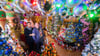 Susanne und Thomas Jeromin stehen inmitten von Weihnachtsbäumen im Wohnzimmer ihres Hauses.