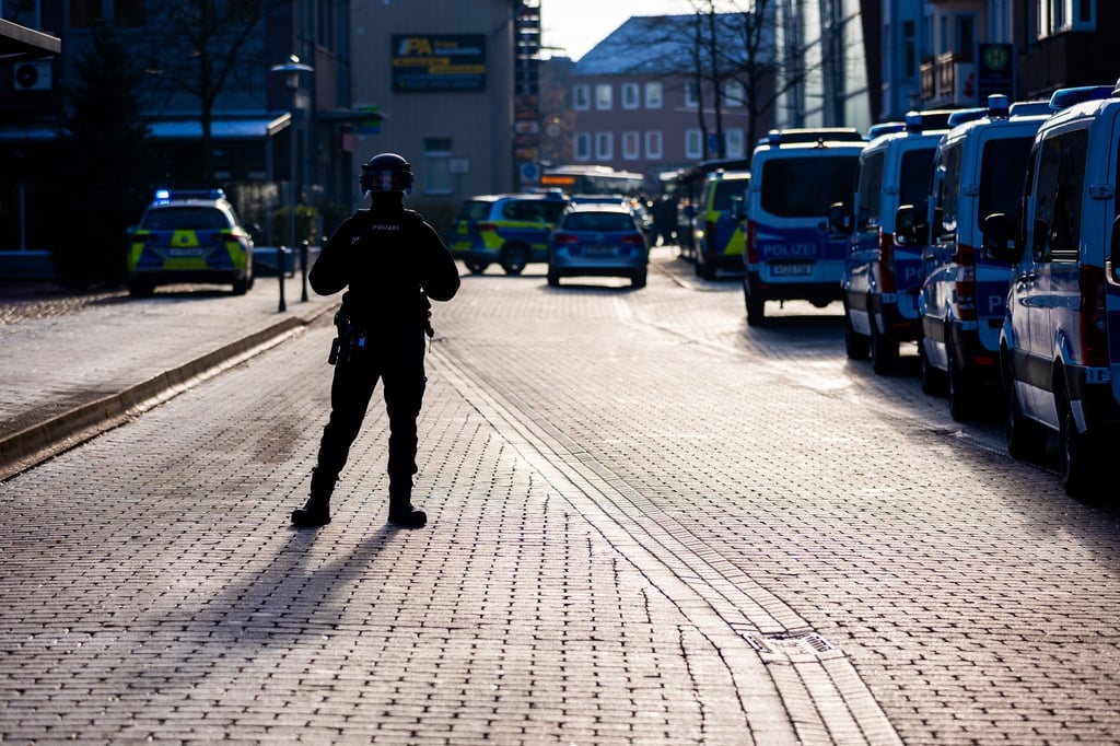 Einsatzfahrzeuge der Polizei stehen vor einem Jobcenter in der Nähe des Bahnhofs in Lehrte.