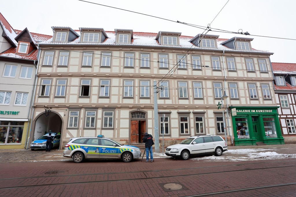 Einsatzfahrzeuge der Polizei stehen nach einer Explosion vor einem Fachwerkhaus.