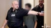 Der Hauptangeklagte wird von Justizbeamten in den Gerichtssaal geführt.