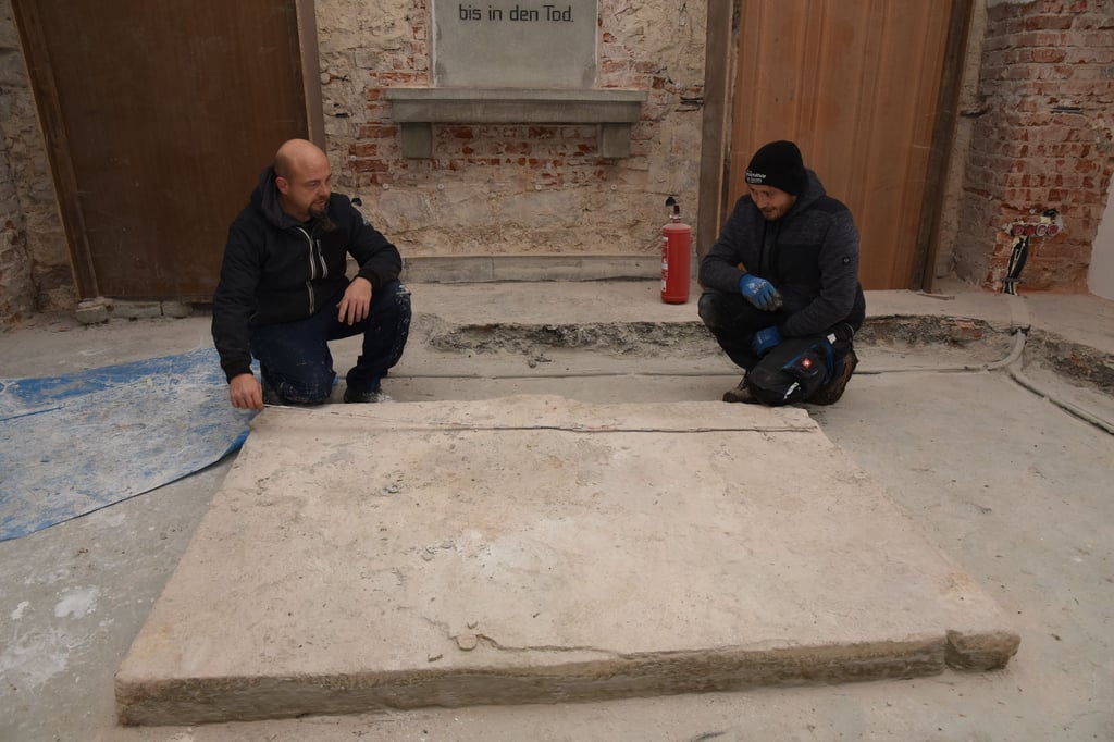 Die Friedhofskapelle Barby wird saniert. Die Handwerker Peter Lehmann (l.) und Gordon Bittkau messen die Größe der mächtigen Grabplatte aus, die gefunden wurde. Sie ist zwei Meter lang und 1.35 Meter breit. Sie zu bergen, dürfte keine leichte Aufgabe sein.