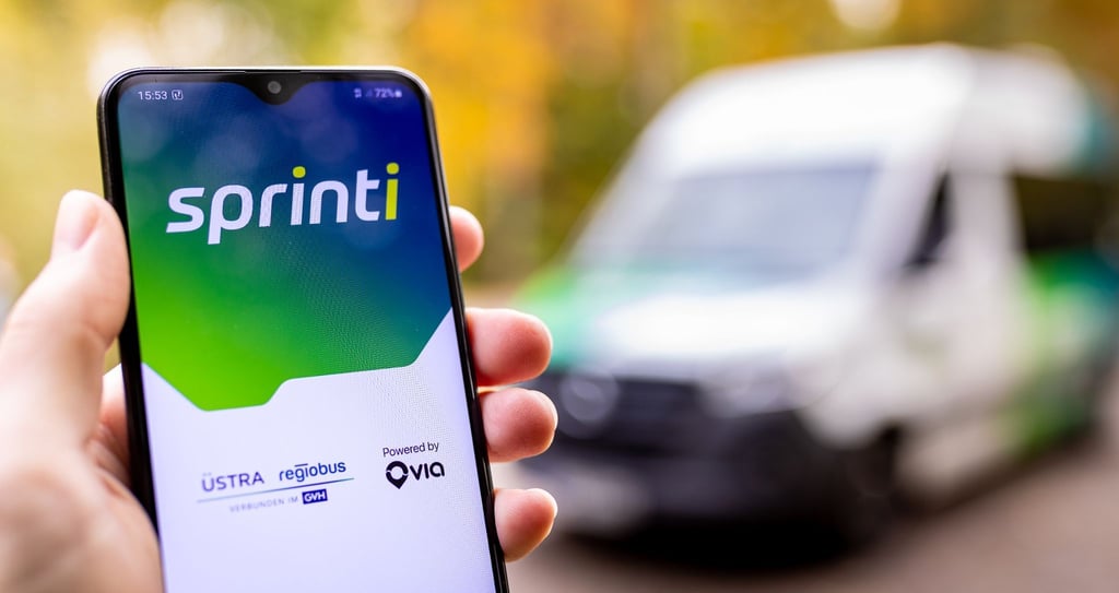 Eine Hand hält ein Smartphone auf dessen Bildschirm die Startmaske der App „Sprinti“, einem Projekt der Üstra Hannoversche Verkehrsbetriebe und Regiobus, zu sehen ist.
