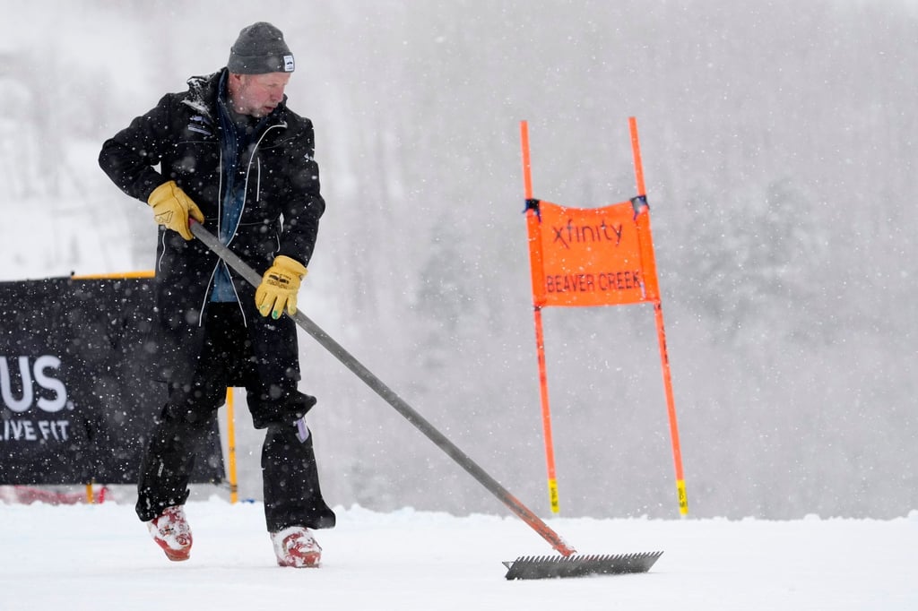 Ein Arbeiter räumt vor der Absage des Rennens Schnee von der Strecke.