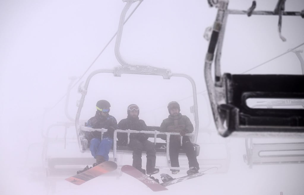 Snowboarder fahren im Snowpark Oberhof mit dem Skilift.