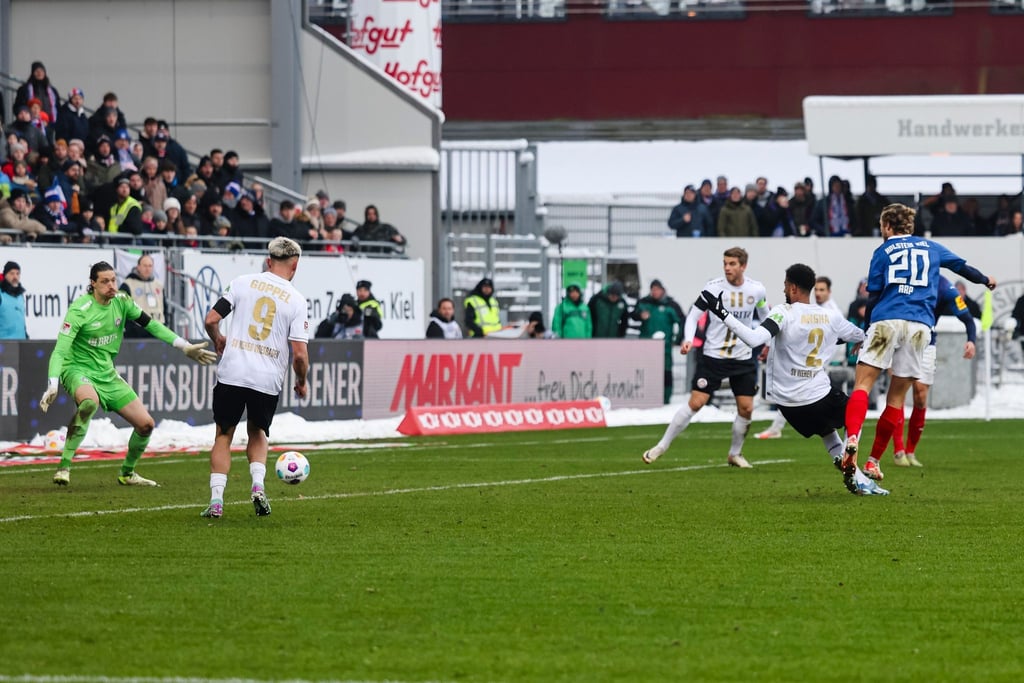 Kiels Fiete Arp (r) trifft zum 2:0 gegen Wiesbadens Torwart Florian Stritzel.