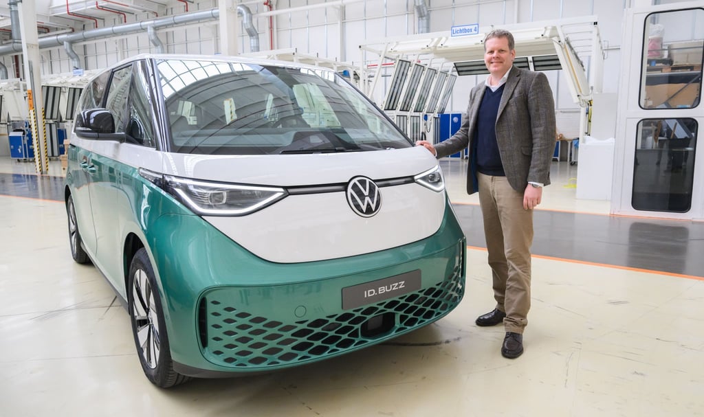 Carsten Intra, Vorstand Volkswagen Nutzfahrzeuge, steht neben einem Elektrobus Volkswagen ID.Buzz im Werk von Volkswagen Nutzfahrzeuge in Hannover.