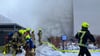 Einsatzkräfte der Feuerwehr löschen einen Brand in einem Wohnhaus in Hellersdorf.