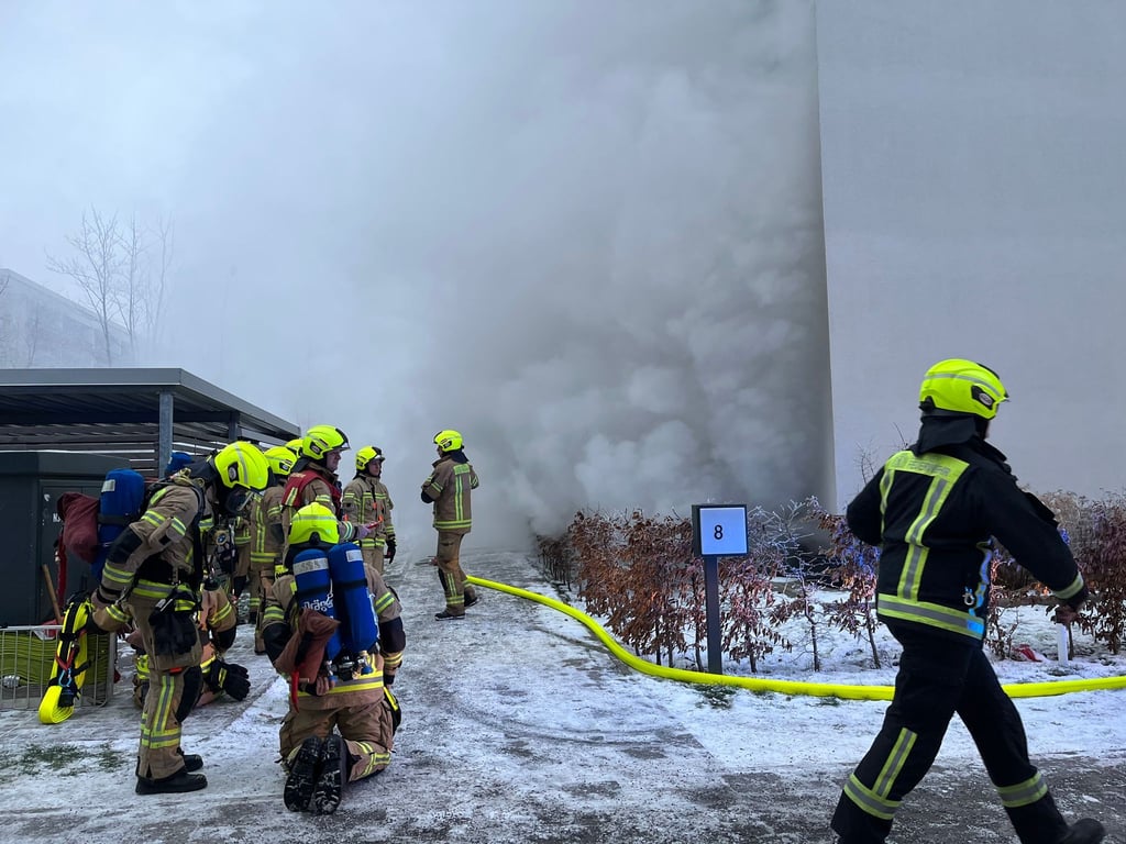 Einsatzkräfte der Feuerwehr löschen einen Brand in einem Wohnhaus in Hellersdorf.