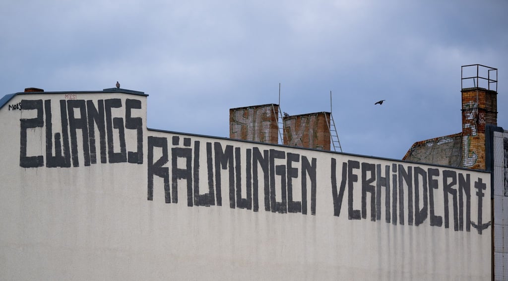 Auf der Brandmauer eines Wohnhauses ist der Schriftzug „Zwangsräumungen verhindern“ zu sehen.