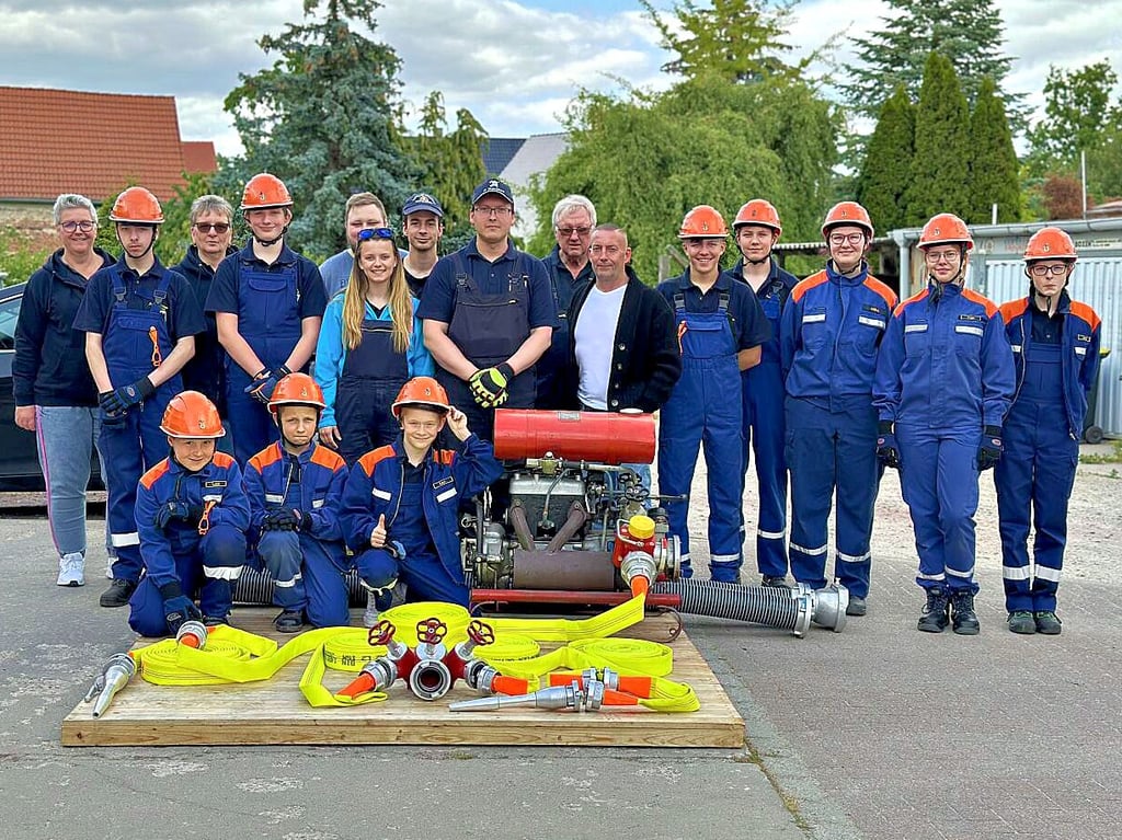 Jens Grüttner (Mitte) über gibt die neuen Schläuche an die Jugendfeuerwehr und Jugendwart Sebastian Otto.